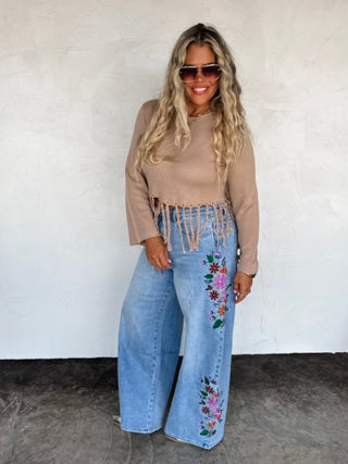 Light wash high-rise wide-leg jeans with floral embroidery on legs, front view