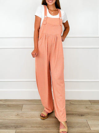 Coral ribbed overalls with wide legs, adjustable straps, and side seam pockets