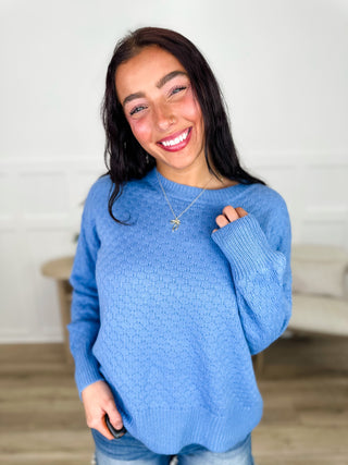 Blue textured knit long-sleeve sweater with crew neck and ribbed cuffs