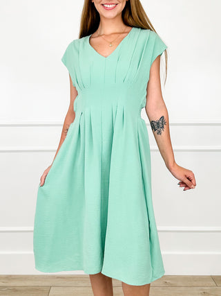 Mint green V-neck swing dress with short cap sleeves and pleated skirt