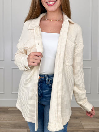 Cream knit button-up shacket with long sleeves, notch collar, textured fabric