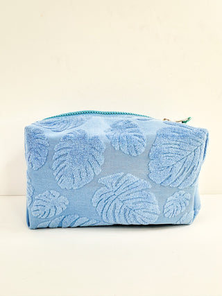 Blue makeup bag with embossed floral pattern and zip top