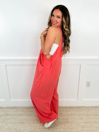 Coral sleeveless jumpsuit with wide-leg drape and side profile
