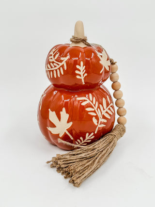 Rust orange stoneware stacked gourd decor with white leaf motif, wooden beads and tassel