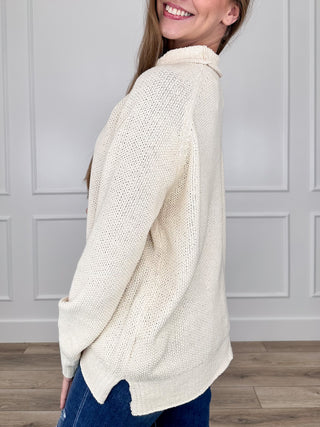 Cream knit long-sleeve mock neck sweater with ribbed cuffs and curved hem