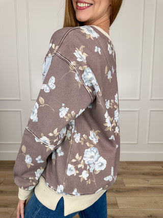 Dark brown crewneck sweatshirt with blue floral and butterfly print, side view