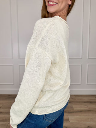 Cream knit long sleeve crewneck sweater, side view with ribbed hem