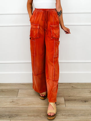 Rust orange wide-leg cargo pants with elastic waist and cargo patch pockets, side view
