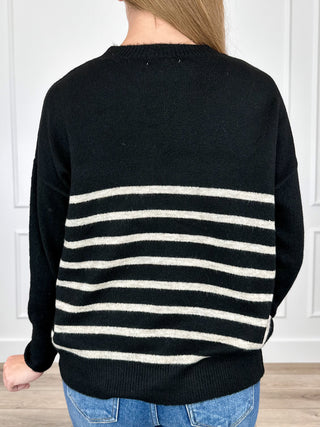 Black long-sleeve knit sweater with back cream stripe bands and ribbed crew neck