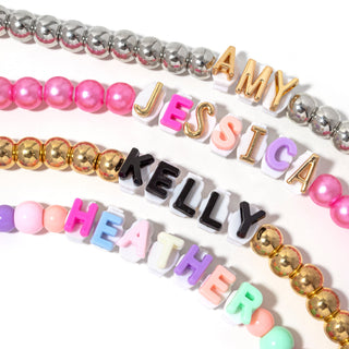 Marble pink beaded phone charger with letter charms and metallic bead accents