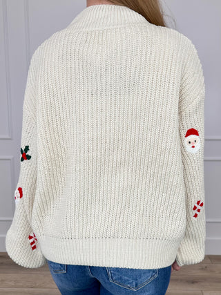 Cream cropped knit sweater back with holiday character and bow prints, ribbed hem