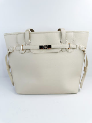 White faux leather tote bag with top handles, side straps, and front buckle detail