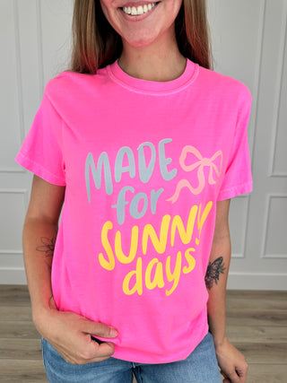Pink cotton short-sleeve crewneck tee with “MADE for SUNNY days” graphic.