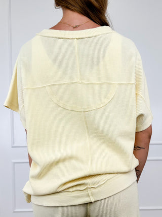 Cream cotton-blend short-sleeve top with crew neck and large back yoke seam