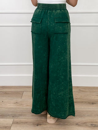 Green high-rise wide-leg pants with back cargo pockets and elastic waist
