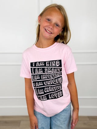 Kids pink short-sleeve graphic tee with black quote stack: I am kind, smart, loved.