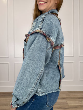 Medium wash denim long-sleeve jacket with distressed seams, side view