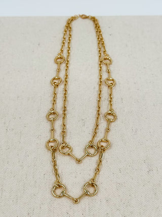 Gold multi-strand necklace with oval ring links and small connector charms