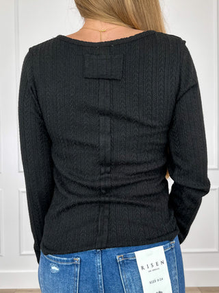 Black long-sleeve top, back view with buttoned yoke detail and textured knit
