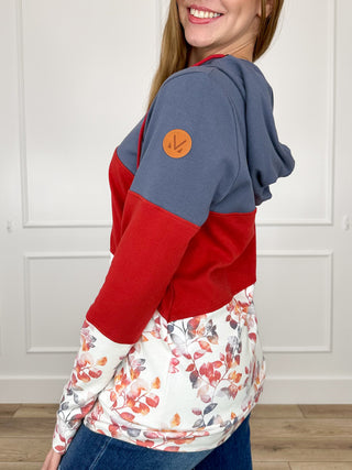 Color-block full-zip hoodie with hood, blue shoulder and red sleeve, floral body, logo patch