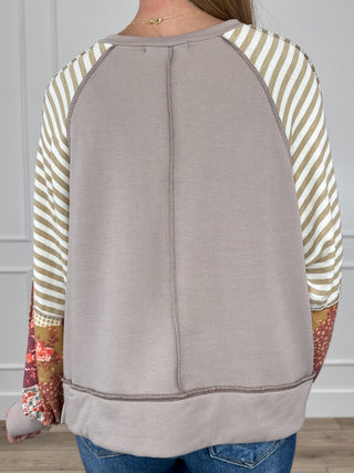 Knit long-sleeve top, back view, striped sleeves with contrast floral cuffs