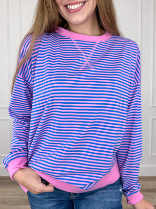 Blue and pink striped long-sleeve top with crew neck and ribbed cuffs