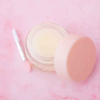 PillowPout collagen lip treatment open jar with pale balm and silicone applicator pad