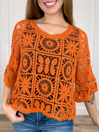Orange crochet short-sleeve top with circular lattice pattern