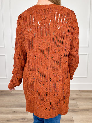 Rust orange knit long-sleeve cardigan back view with repeating diamond openwork pattern