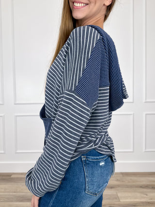 Blue striped hooded button-up long-sleeve top with kangaroo pocket, side view