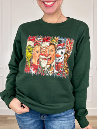 Green crewneck sweatshirt with long sleeves and a colorful festive character graphic on the front
