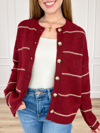 Wine red knit cardigan with long sleeves, button front, and cream striped trim pockets