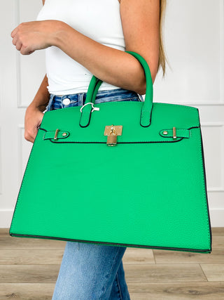 Green faux leather handbag with top handles and gold-tone front clasp hardware