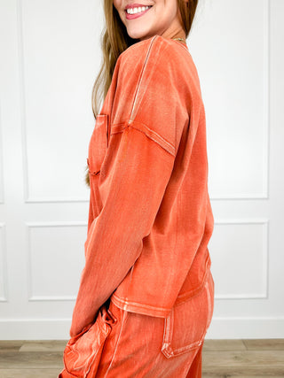 Rust orange cotton long-sleeve top with chest pocket, shown in profile