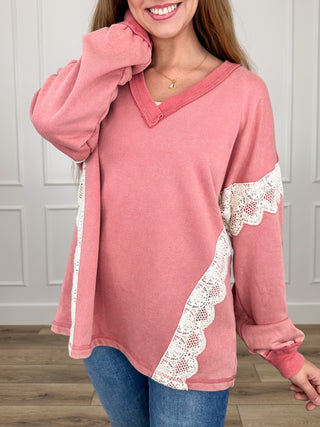 Pink knit long-sleeve top with V-neck and white lace trim on sleeves and hem