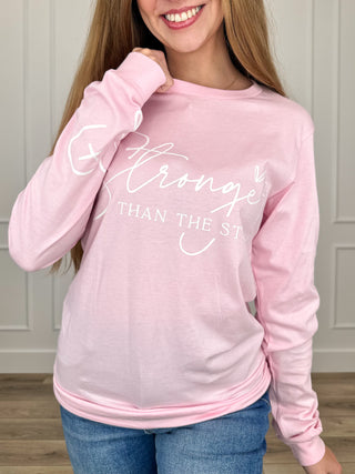 Pink long-sleeve cotton graphic tee with white “Stronger” text, crew neck