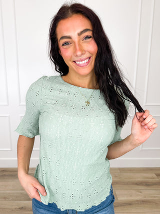 Green 3/4 sleeve knit top with eyelet lace-like pattern and crew neckline