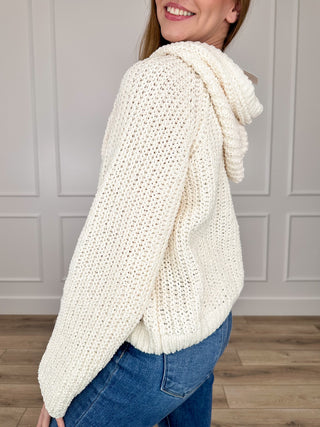 Cream hooded knit sweater top with long sleeves, draped hood side view