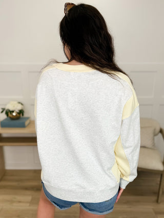 Long-sleeve cotton top, back view with cream body and yellow side panels.