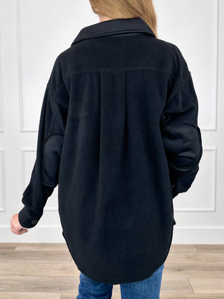 Black long-sleeve button shacket with back yoke and curved hem, rear view