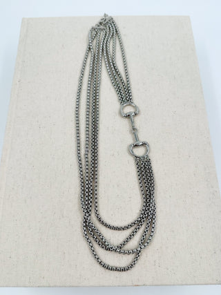 Layered silver-tone chain necklace with oval clasp and multiple draped strands