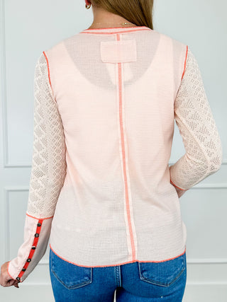 Salmon knit long sleeve top with back yoke panel and vertical contrast trim