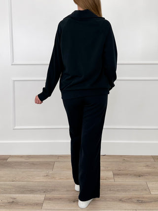 Black two-piece set with zip-up hoodie and matching pants, back view