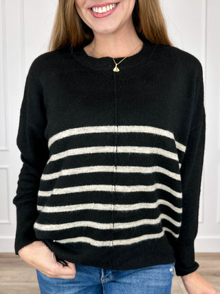 Black long-sleeve knit sweater top with wide cream stripe bands across chest