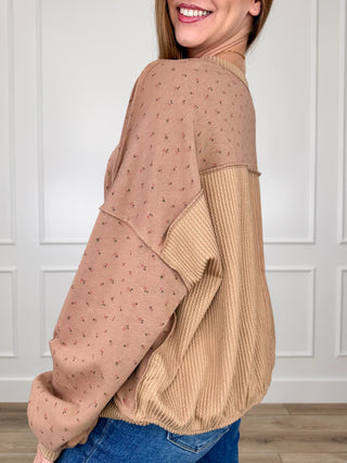 Long sleeve knit top with allover dot pattern and contrasting ribbed hem panel.