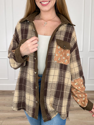 Brown plaid button-up shacket with contrast floral sleeve panels and chest pockets