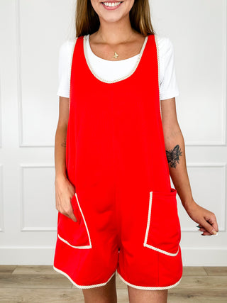 Red sleeveless romper with white trim and patch pockets