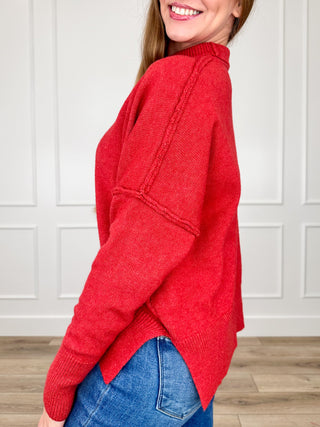 Red knit long-sleeve sweater with crew neck, side drape, and ribbed cuffs