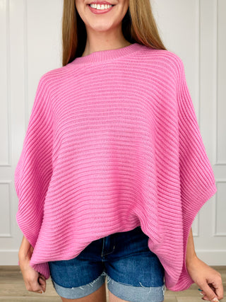 Pink knit poncho top with wide neck and draped 3/4 sleeves