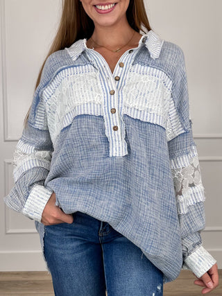 Blue and white cotton top with button front, lace patches, and ruffled sleeve cuffs